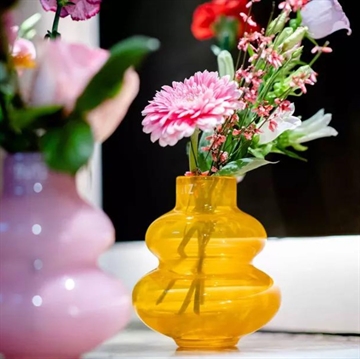 Vasen klæder både et par løse blomster og en buket markblomster